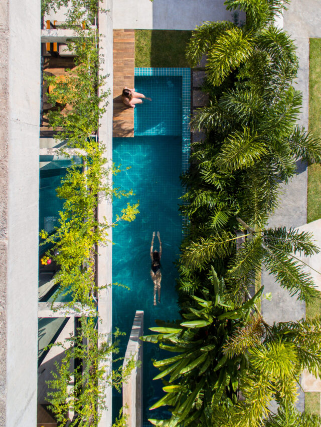 Piscina se integra às salas e cozinha nessa casa